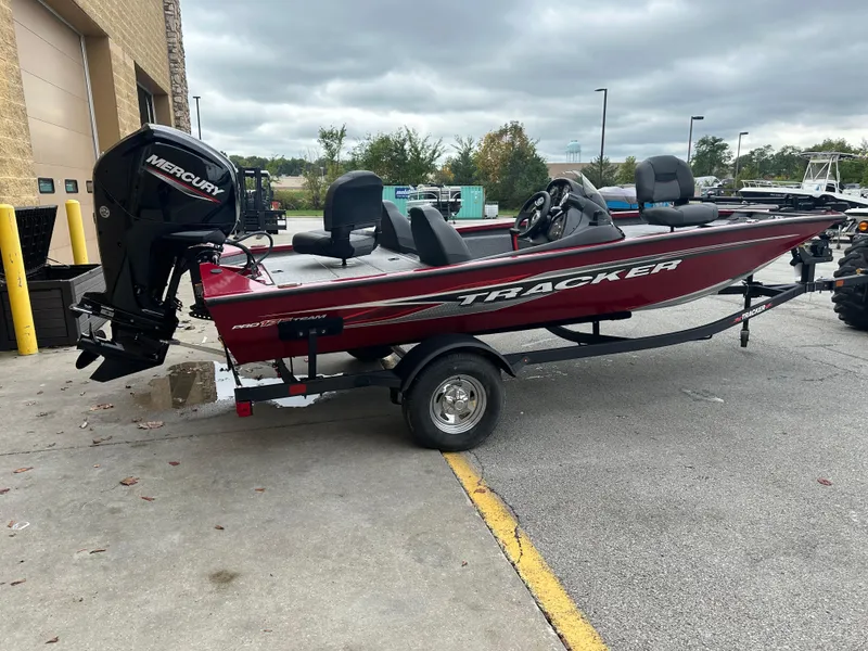 Slide: The Image of 2024 Tracker Pro Team 175 TXW fishing boat with Mercury engine, parked outdoors. - 2