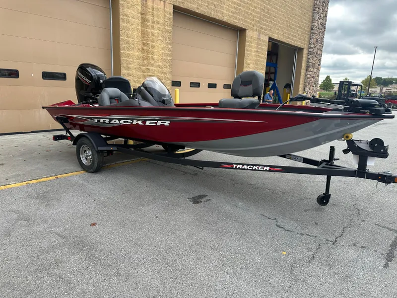 Slide: The Image of 2024 Tracker Pro Team 175 TXW boat on trailer, parked outside a garage. - 3