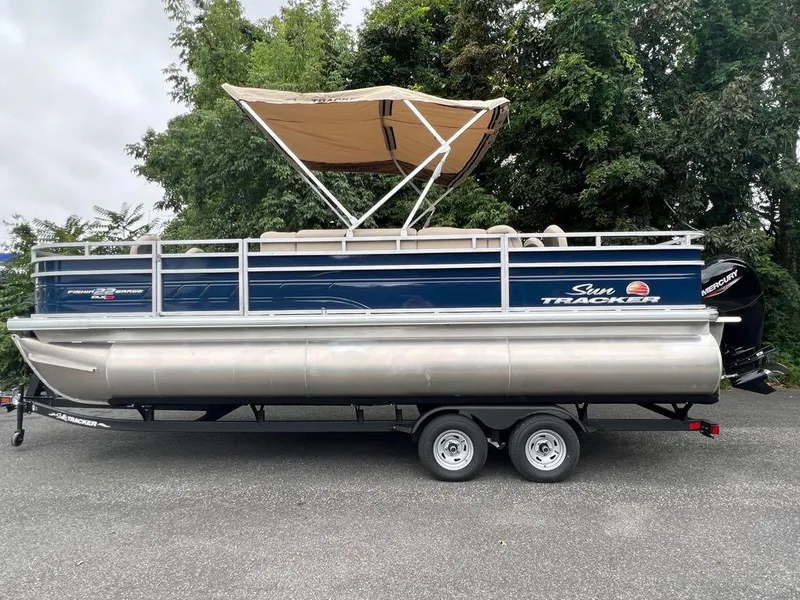 The Image of 2024 Sun Tracker Fishin' Barge 22 XP3 pontoon boat on trailer. - 0