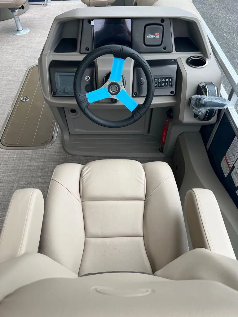 Slide: The Image of 2024 Sun Tracker Fishin' Barge 22 XP3 helm with steering wheel and captain's chair. - 8