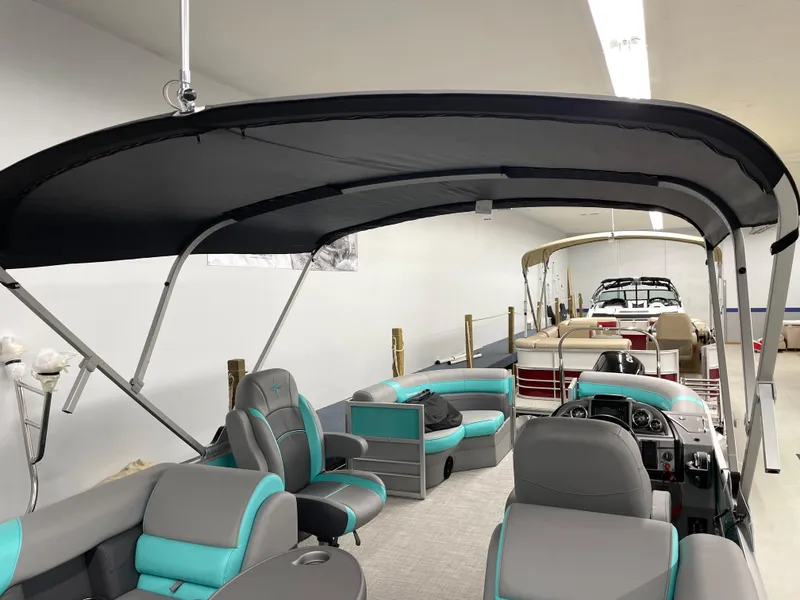 Slide: The Image of 2023 Berkshire 22 RFX CTS pontoon boat with teal and gray interior under a black canopy. - 6