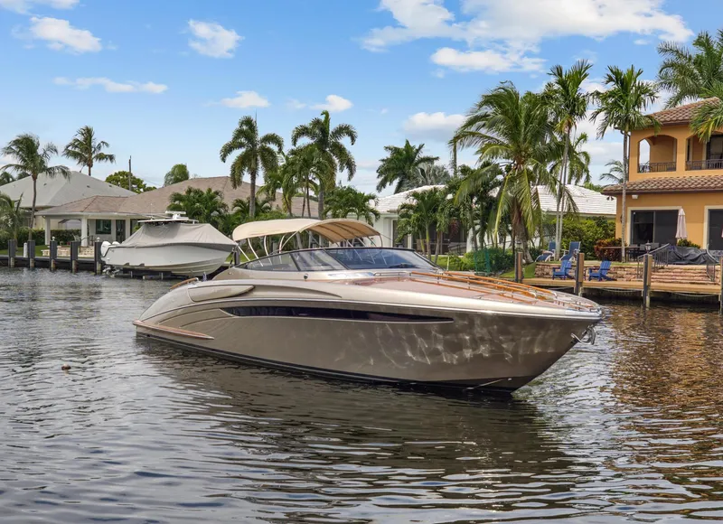 The Image of Luxurious 2010 Riva Rama boat cruising in a tropical waterfront setting. - 0