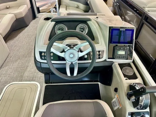 Slide: The Image of 2024 Barletta Cabrio 22UC boat dashboard with steering wheel and control panel. - 4