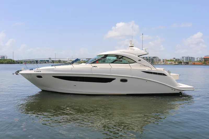 The Image of 2013 Sea Ray 410 Sundancer yacht on calm water, clear sky background. - 0
