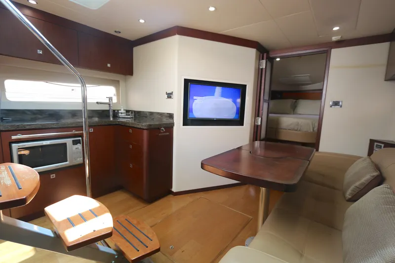 Slide: The Image of Interior of 2013 Sea Ray 410 Sundancer yacht with kitchen, seating, and TV. - 11