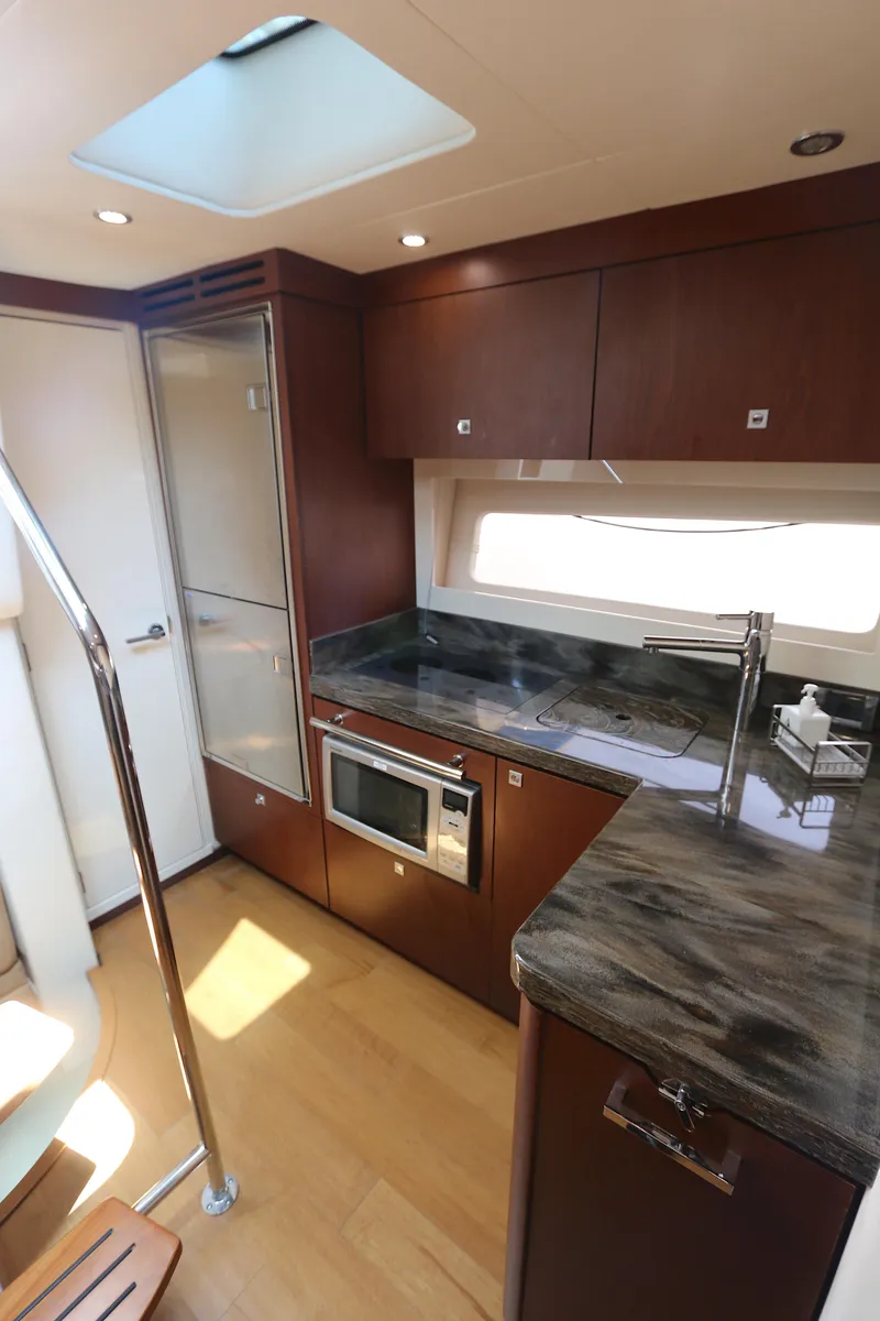 Slide: The Image of 2013 Sea Ray 410 Sundancer yacht kitchen with modern appliances and sleek design. - 12