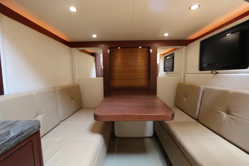 Slide: The Image of Luxurious interior of 2013 Sea Ray 410 Sundancer yacht with beige seating and wooden table. - 13