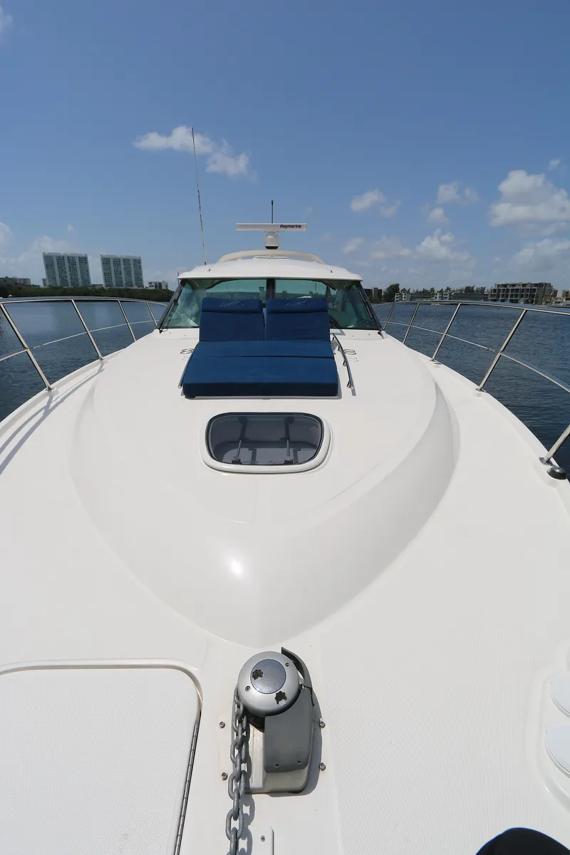 Slide: The Image of 2013 Sea Ray 410 Sundancer yacht on calm water under clear blue sky. - 20