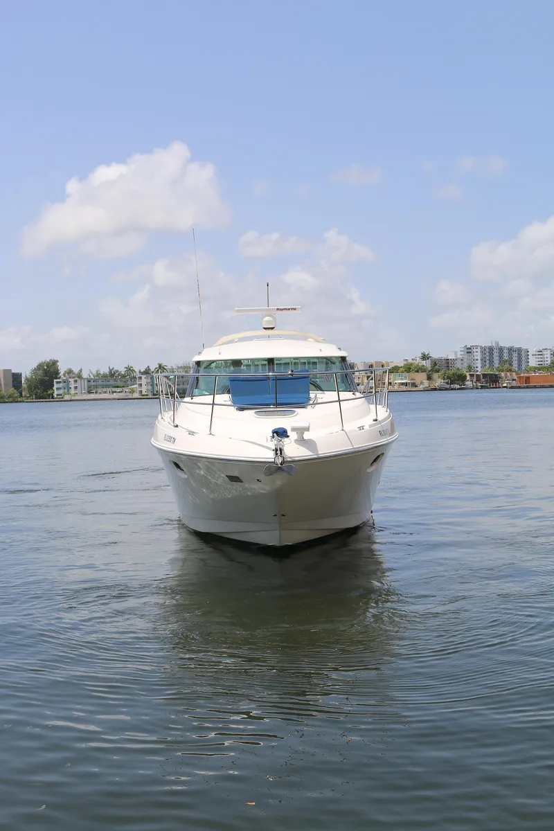 Slide: The Image of 2013 Sea Ray 410 Sundancer yacht on calm water under a clear sky. - 26