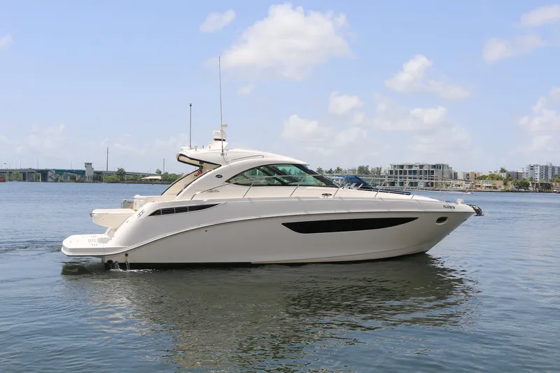 Slide: The Image of 2013 Sea Ray 410 Sundancer yacht on calm water under a clear sky. - 27