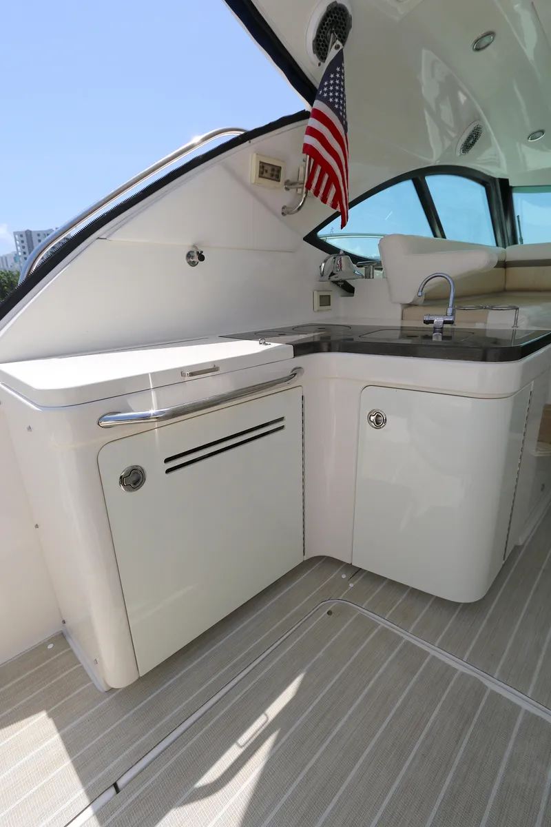 Slide: The Image of 2013 Sea Ray 410 Sundancer yacht kitchenette with sink and American flag. - 5