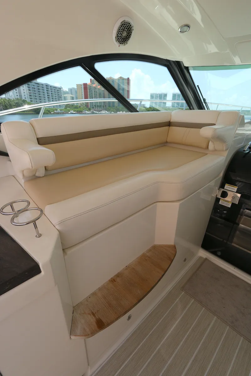 Slide: The Image of 2013 Sea Ray 410 Sundancer interior with beige seating and cityscape view. - 7