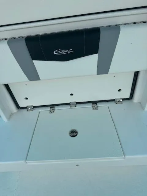 Slide: The Image of 2024 Robalo 270 CC boat storage compartment with sleek design and secure latch. - 11