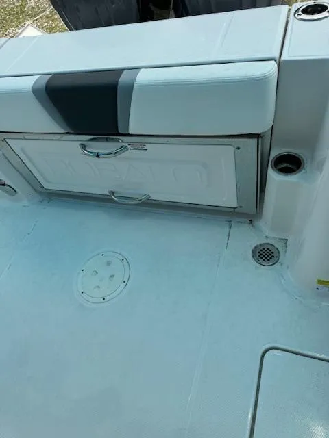 Slide: The Image of 2024 Robalo 270 CC boat deck with storage compartment and seating. - 14
