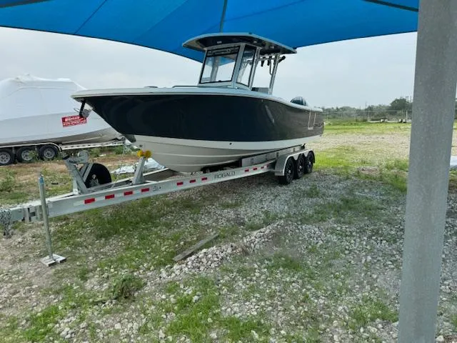 Slide: The Image of 2024 Robalo 270 CC boat on trailer under blue canopy. - 4