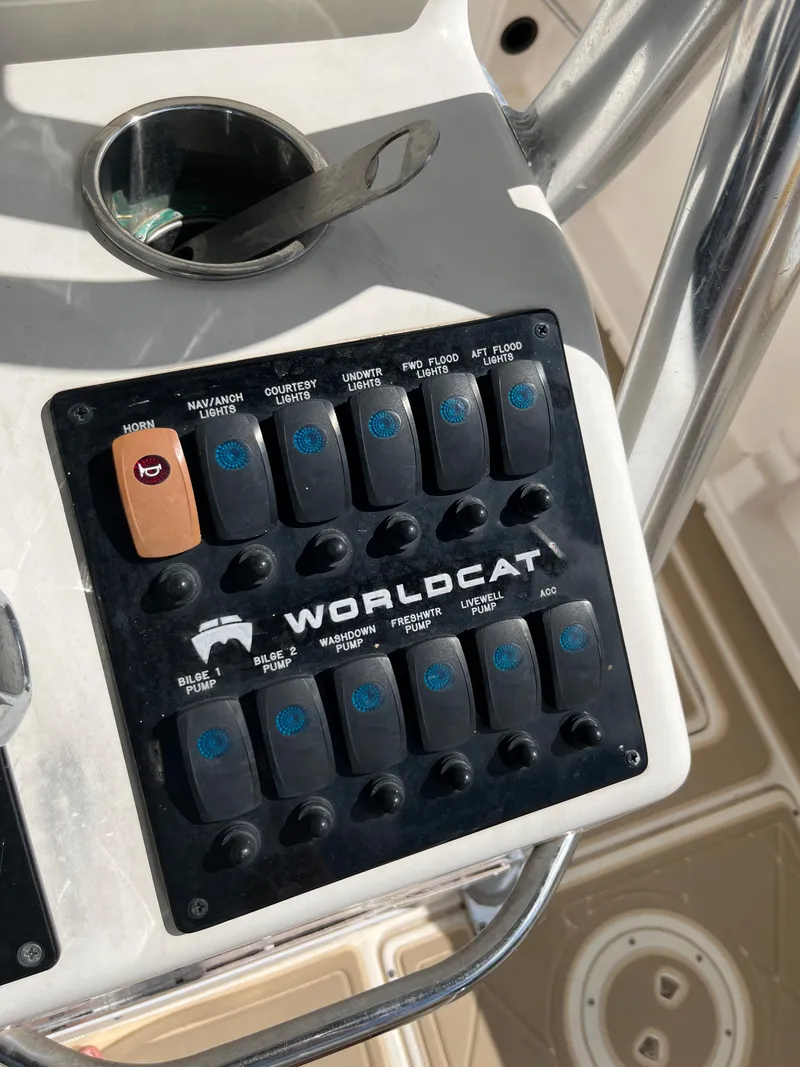 Slide: The Image of Control panel of a 2004 World Cat 270 SF boat with various switches. - 26