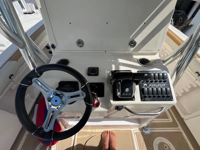 Slide: The Image of 2004 World Cat 270 SF boat helm with steering wheel and control panel. - 28