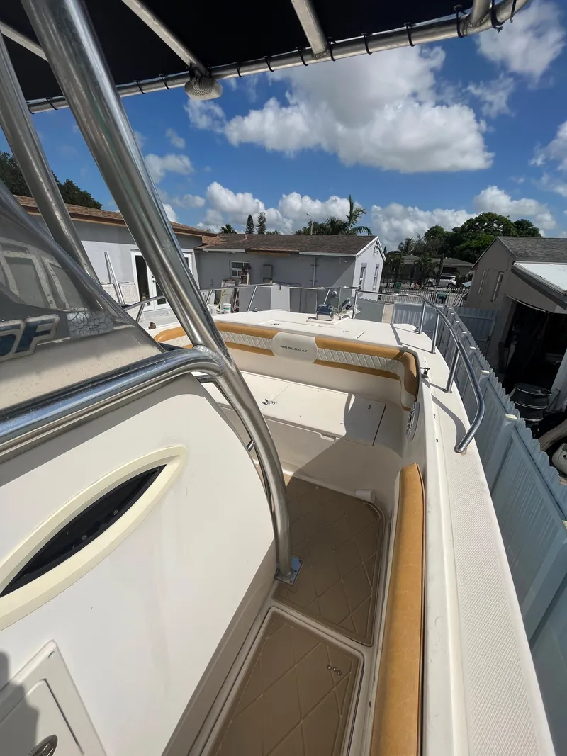 Slide: The Image of 2004 World Cat 270 SF boat deck with seating and canopy under a sunny sky. - 31