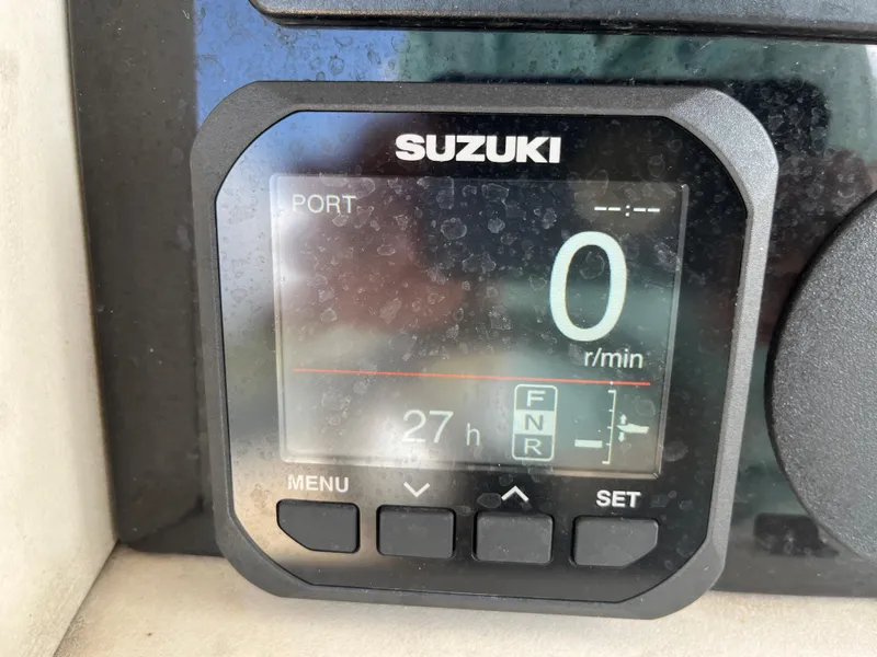Slide: The Image of Suzuki engine display on a 2004 World Cat 270 SF boat showing 27 hours. - 44