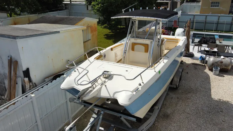 Slide: The Image of 2004 World Cat 270 SF boat on a trailer in a yard. - 5