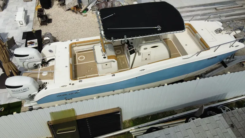 Slide: The Image of 2004 World Cat 270 SF boat with dual Suzuki outboard engines, docked. - 8