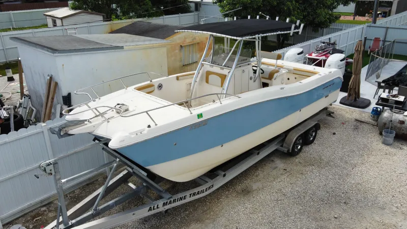Slide: The Image of 2004 World Cat 270 SF boat on a trailer in a yard. - 9