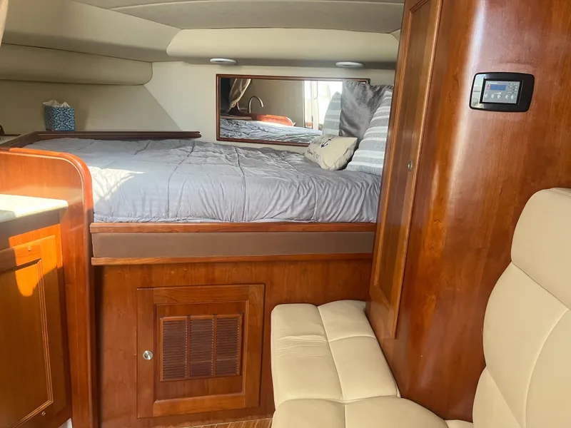 Slide: The Image of 2008 Rampage 30 Express cabin interior with bed, wood cabinetry, and seating. - 10