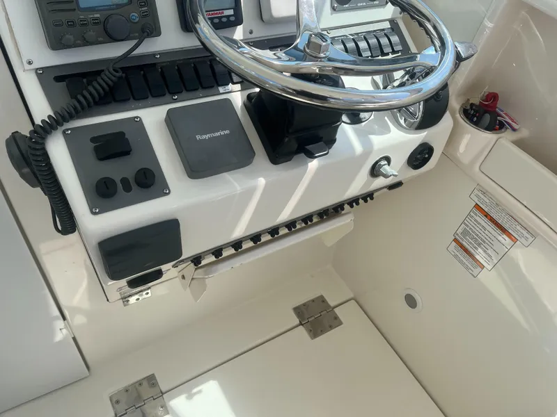 Slide: The Image of 2008 Rampage 30 Express boat helm with steering wheel and control panel. - 11