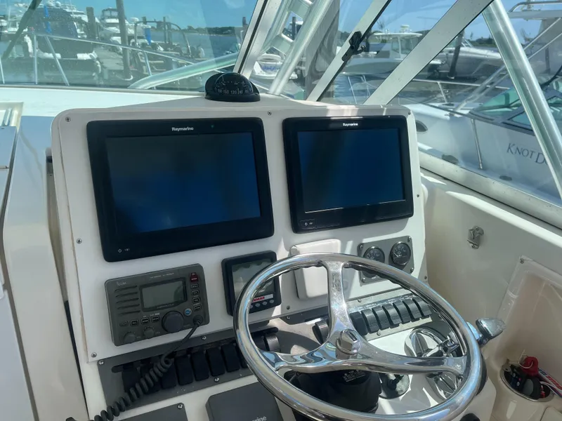 Slide: The Image of 2008 Rampage 30 Express helm with dual Raymarine displays and steering wheel. - 12