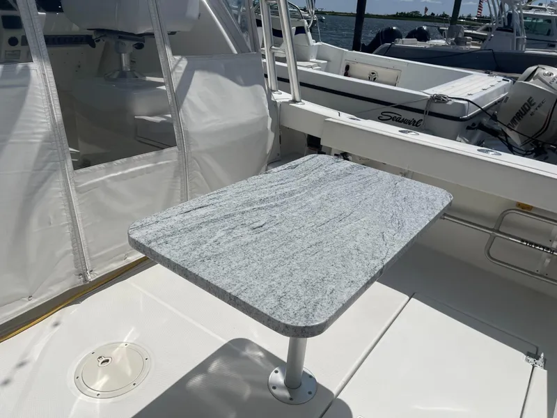 Slide: The Image of 2008 Rampage 30 Express boat with a sleek, modern deck table. - 24