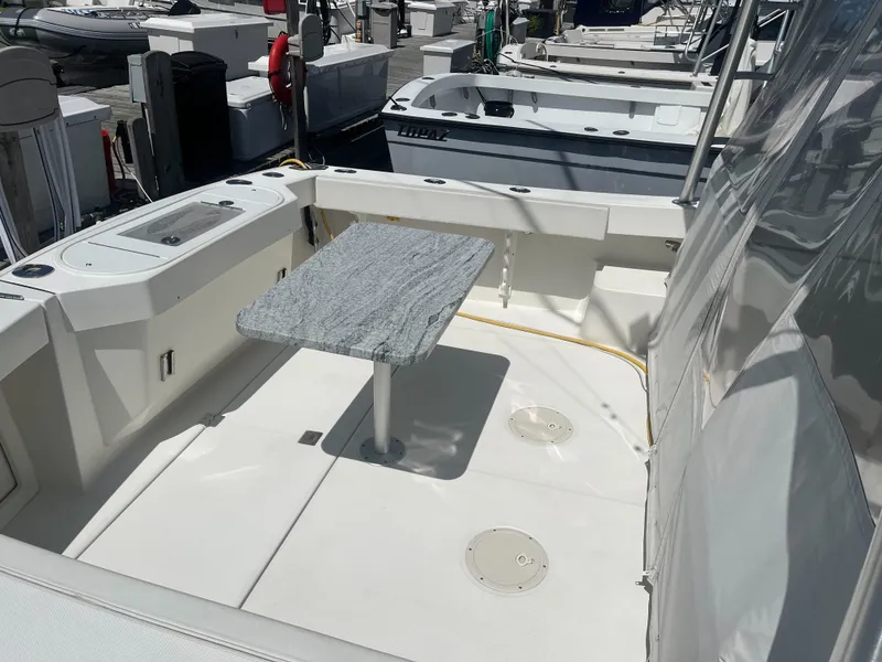 Slide: The Image of 2008 Rampage 30 Express boat deck with table, docked at marina. - 26