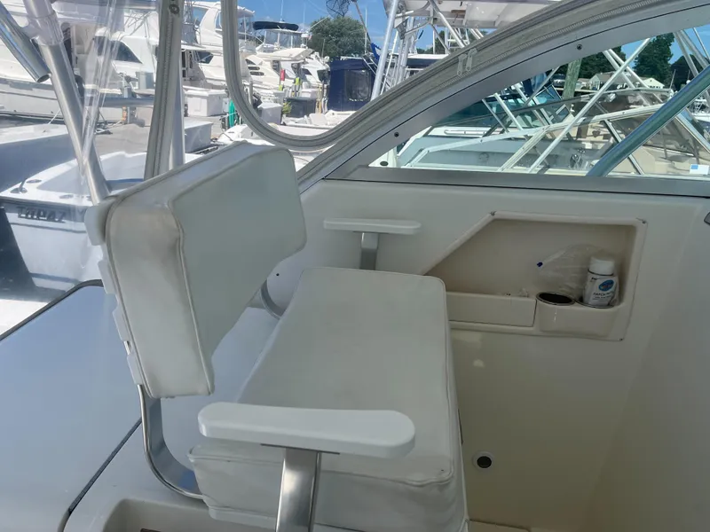 Slide: The Image of 2008 Rampage 30 Express boat interior with white seating and storage compartment. - 32