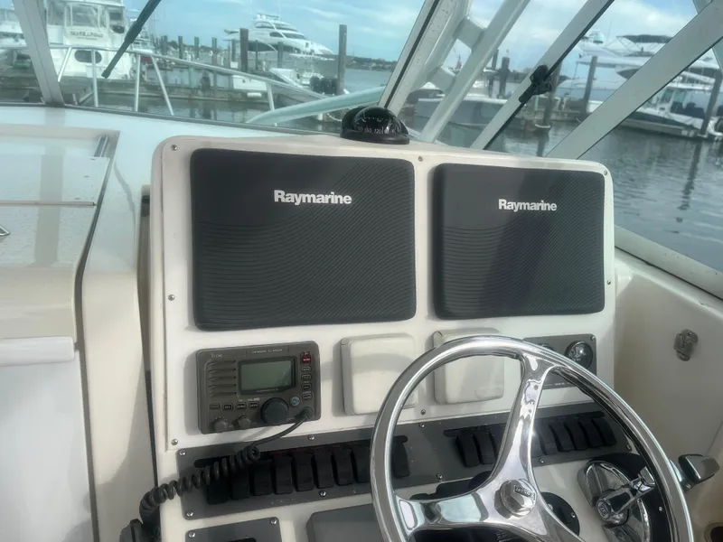 Slide: The Image of 2008 Rampage 30 Express helm with Raymarine electronics and steering wheel, docked at marina. - 35