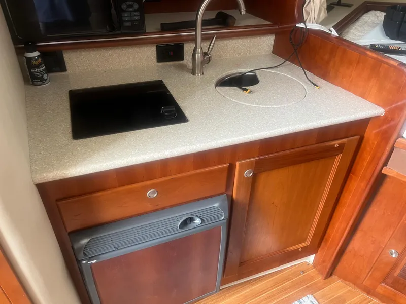 Slide: The Image of 2008 Rampage 30 Express boat kitchen with sink, stove, and wooden cabinetry. - 39