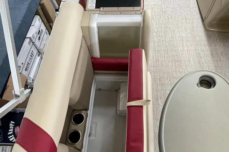 Slide: The Image of 2023 Berkshire 22CL CTS boat interior with beige and red seating, cup holders, and storage. - 9