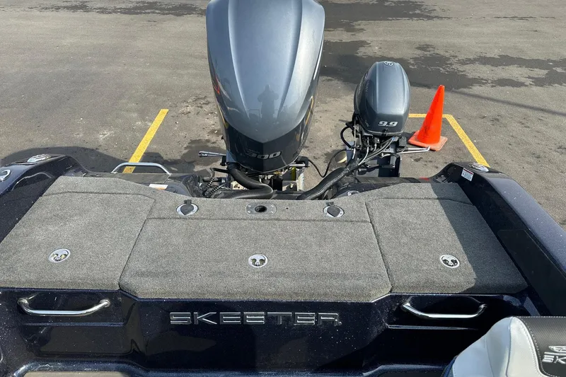 Slide: The Image of 2024 Skeeter WX2200 boat with dual outboard motors in a parking lot. - 8