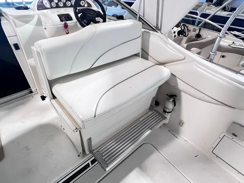 Slide: The Image of 2001 Larson 270 boat interior with white seating and control panel. - 10