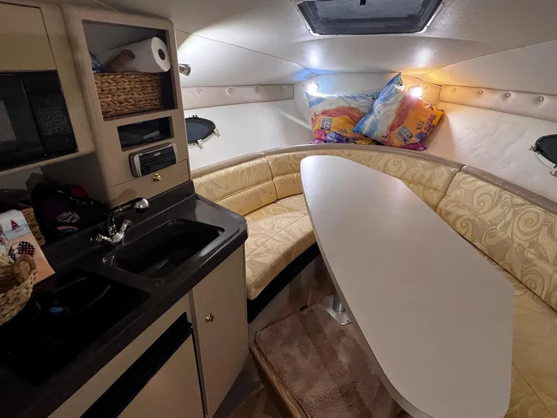 Slide: The Image of 2001 Larson 270 boat interior with kitchenette and dining area. - 11