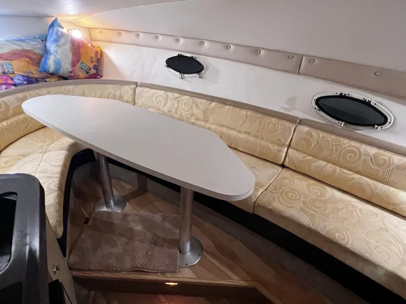 Slide: The Image of Interior of 2001 Larson 270 boat with beige seating and oval table. - 12