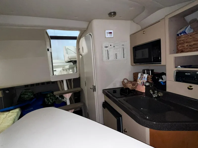 Slide: The Image of Interior cabin of a 2001 Larson 270 boat with kitchenette and seating area. - 14