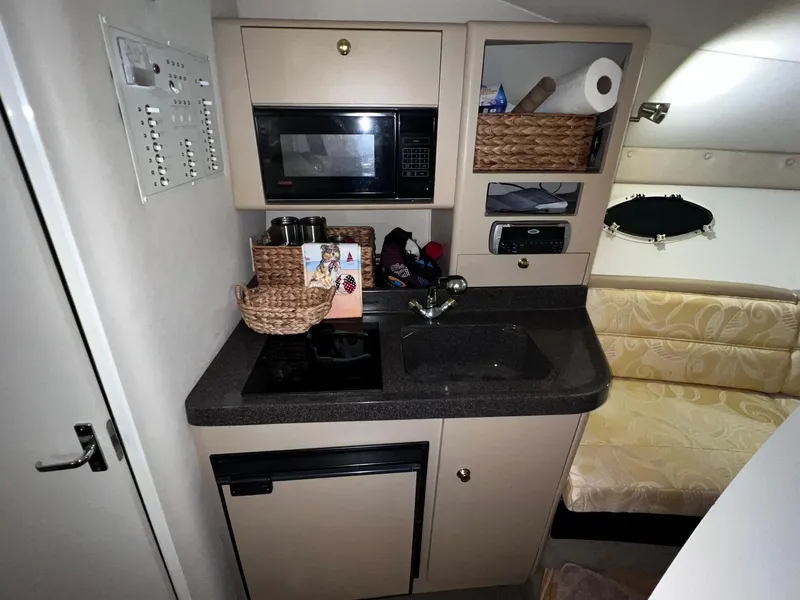 Slide: The Image of Compact kitchen area in a 2001 Larson 270 boat with microwave, sink, and storage. - 15