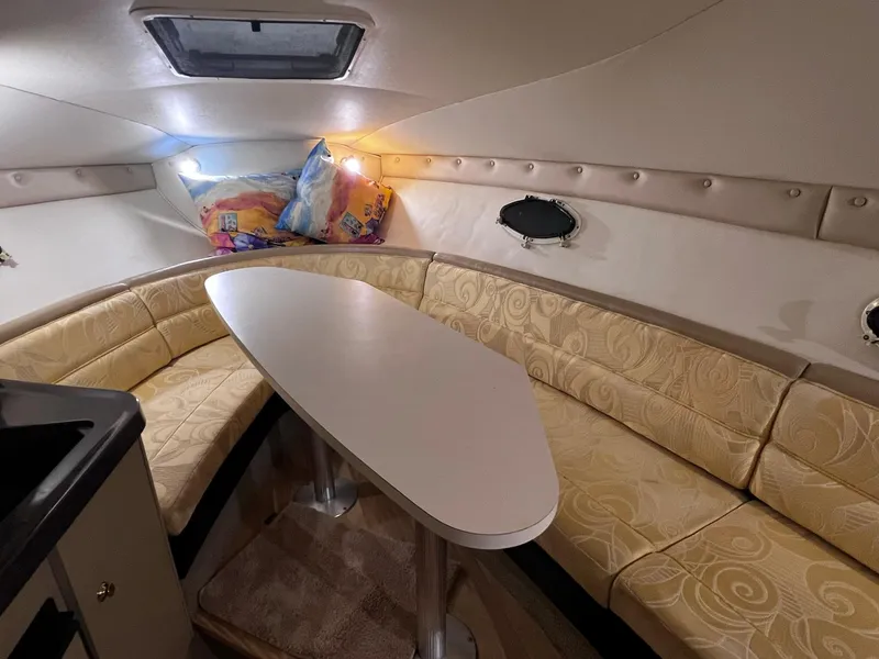 Slide: The Image of 2001 Larson 270 boat interior with beige seating and dining table. - 18