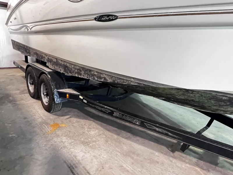 Slide: The Image of 2001 Larson 270 boat on a dual-axle trailer in a garage. - 34