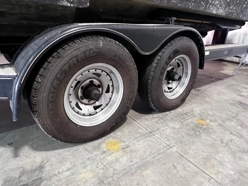 Slide: The Image of Trailer wheels of a 2001 Larson 270 boat on a concrete floor. - 37