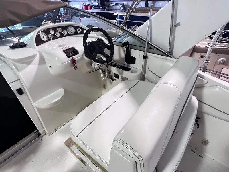Slide: The Image of 2001 Larson 270 boat cockpit with steering wheel and white seating. - 9