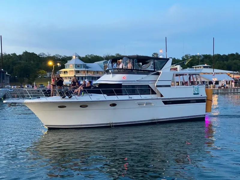The Image of 1990 Carver 48 Californian yacht cruising near a marina at dusk. - 1