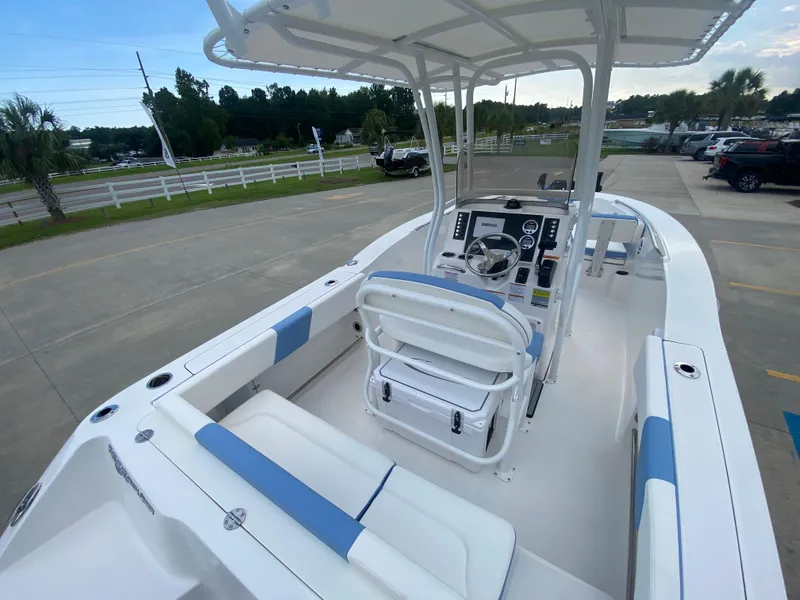 Slide: The Image of 2024 Robalo 202 EXPLORER boat interior with white and blue seating, center console, and steering wheel. - 6