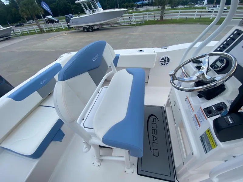 Slide: The Image of 2024 Robalo 202 EXPLORER boat interior with blue and white seating and steering console. - 10