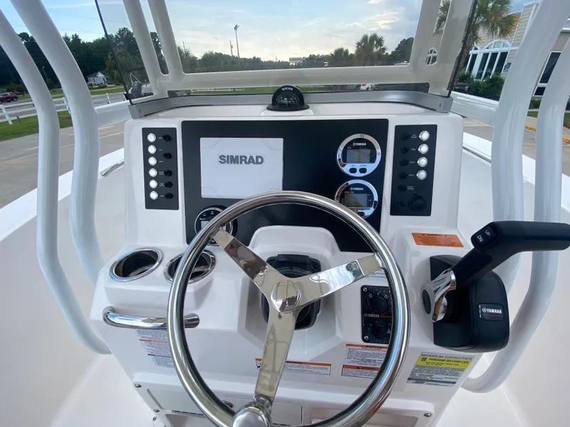 Slide: The Image of 2024 Robalo 202 EXPLORER boat dashboard with Simrad navigation system and steering wheel. - 11