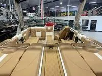 Slide: The Image of 2024 MasterCraft XT22 T boat interior with tan upholstery in showroom. - 7